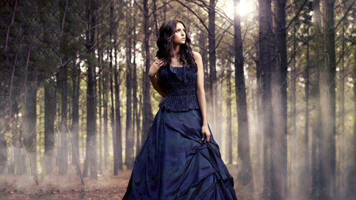 Nina Dobrev in a blue dress in a forest