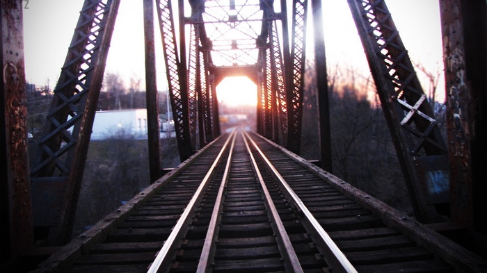 Train tracks on a bridge at sunset
