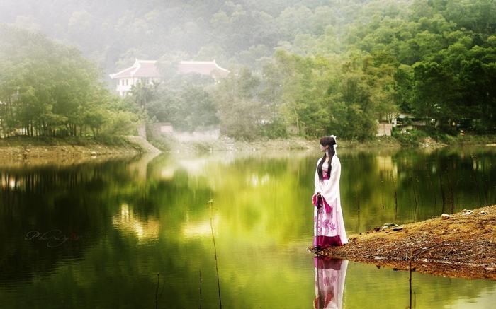 Woman in traditional Chinese dress by a lake