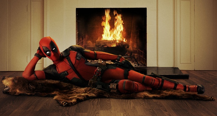 Deadpool lounging by a fireplace on a bear rug