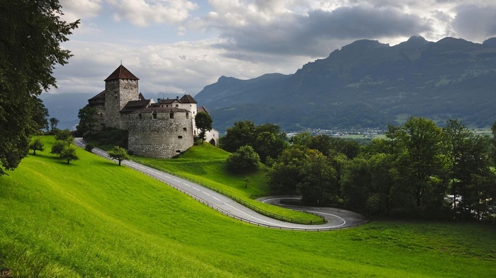 Vaduz Castle in Liechtenstein with winding road and mountains