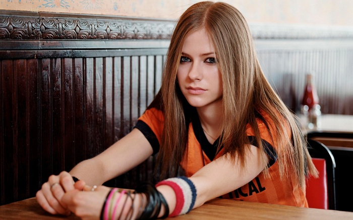 Avril Lavigne sitting at a table