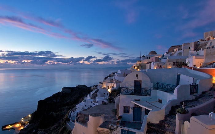 Santorini, Greece at twilight with whitewashed buildings on a cliffside