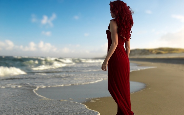 Woman in red dress on a beach