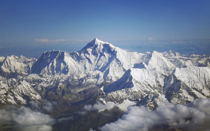 Aerial view of snow-capped mountains under a blue sky