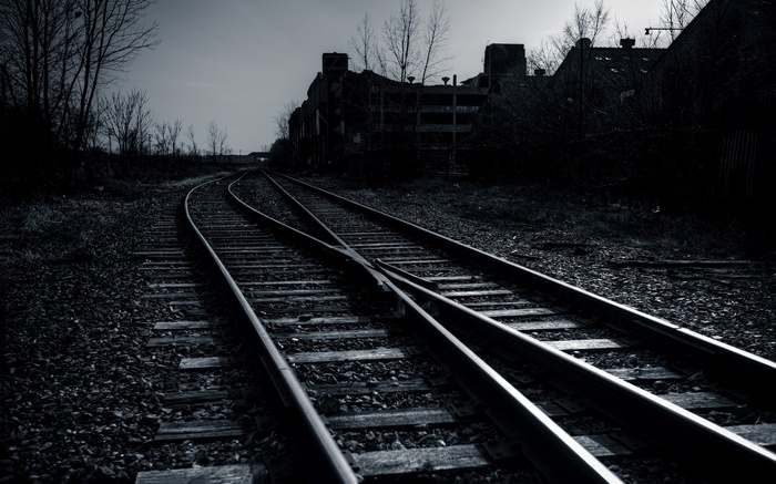 Abandoned railway tracks leading to derelict buildings