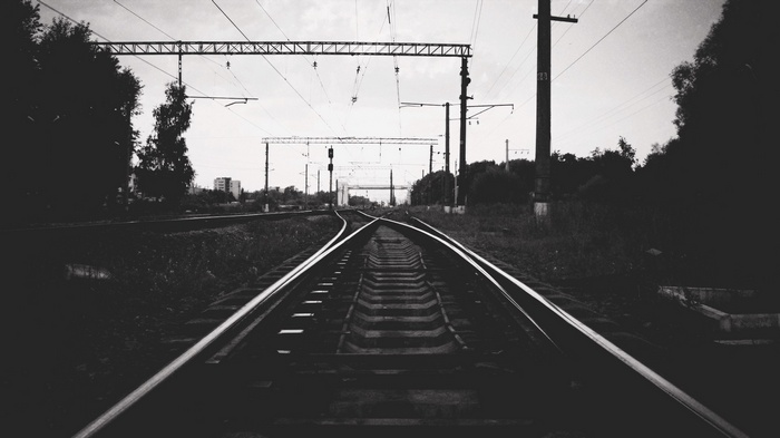 Monochrome railway tracks with overhead wires