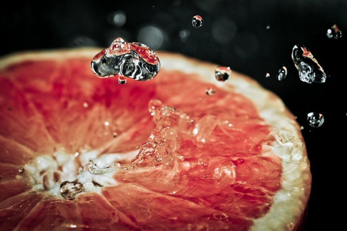 Close-up of grapefruit slice with splashing water