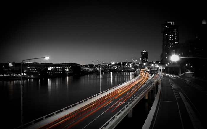 Cityscape with light trails on a bridge at night