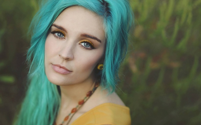 Woman with bright blue dyed hair and yellow eyeshadow