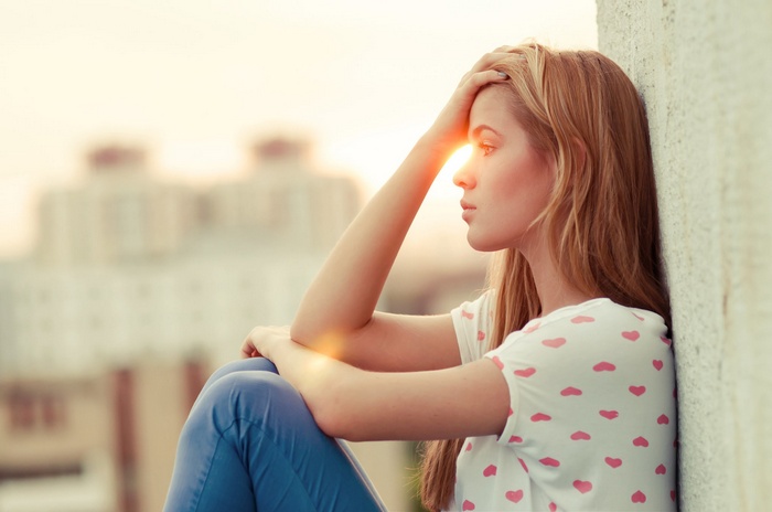 Woman with hands on head in sunlight