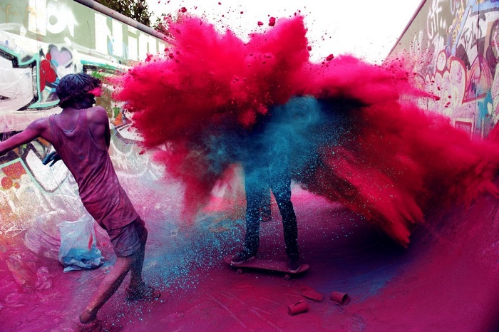People throwing colorful powder in a skatepark