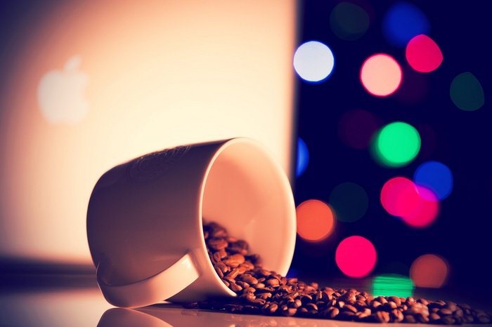 White coffee cup spilling coffee beans