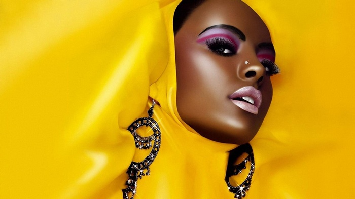 Woman with dramatic makeup and yellow fabric