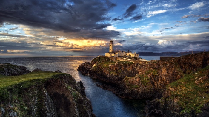 Lighthouse on a rocky cliff overlooking the sea in Ireland