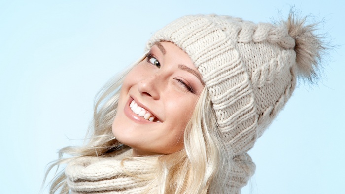 Woman winking and smiling in a knitted hat