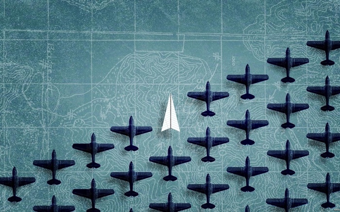 Paper airplane leading a fleet of dark airplanes on a map