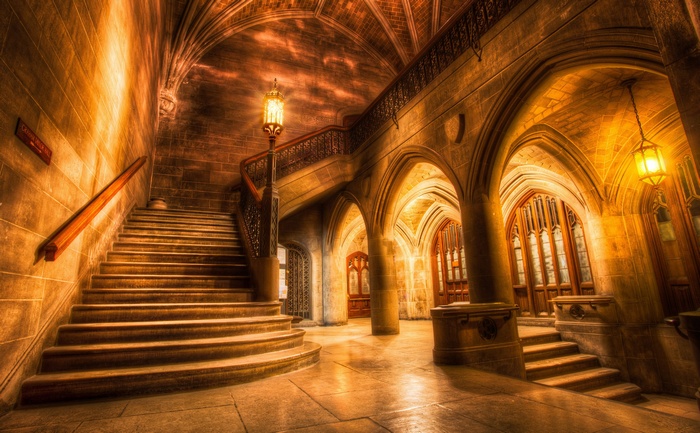 Interior of an old building with a grand staircase and arches