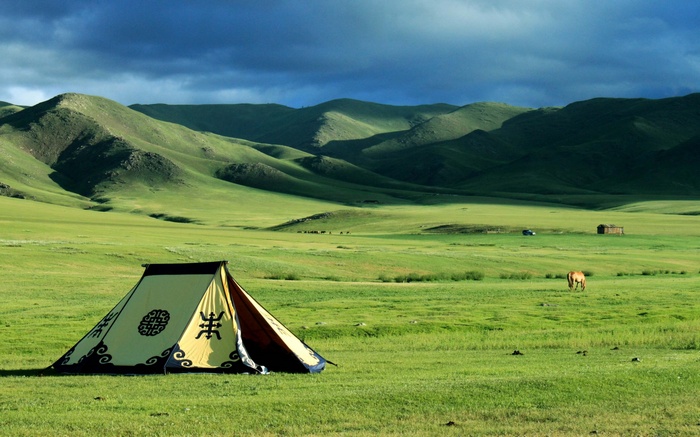 Tent in a Mongolian steppe with rolling hills