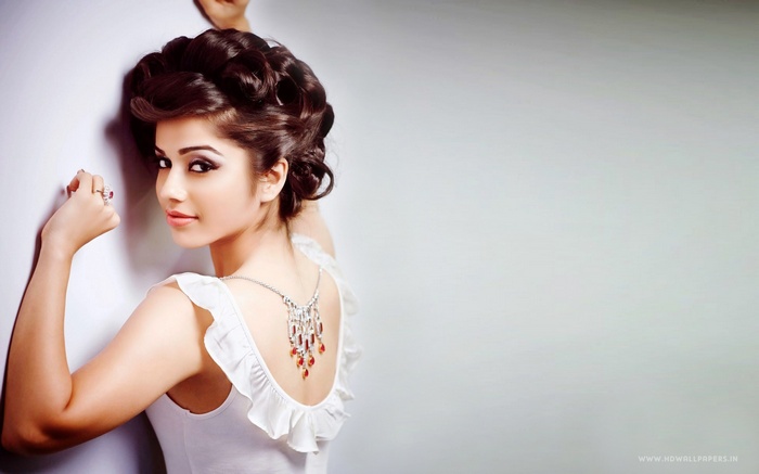 Bollywood celebrity posing against a white wall