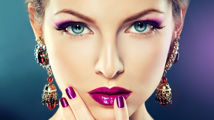 Woman with purple makeup and earrings