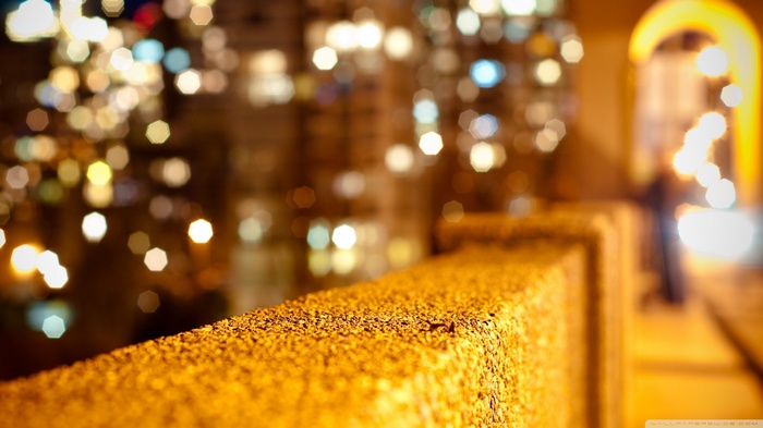 Bokeh lights and textured railing at night