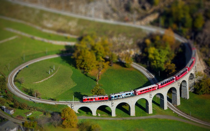 Red and blue trains on a viaduct in Switzerland