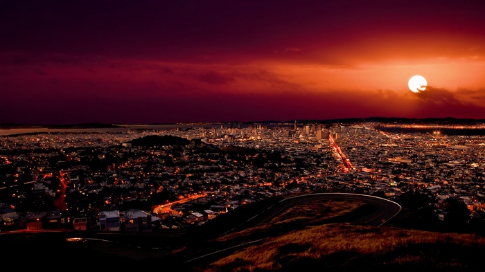 Cityscape at sunset with a bright sun
