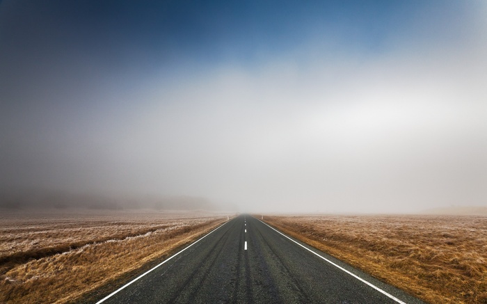 A foggy road through a dry landscape