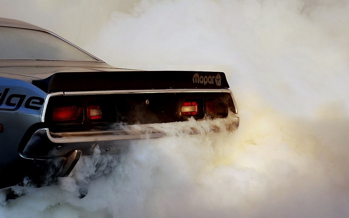 Dodge car doing a burnout with Mopar logo