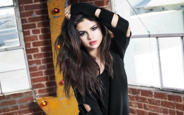 Selena Gomez posing in a black sweater