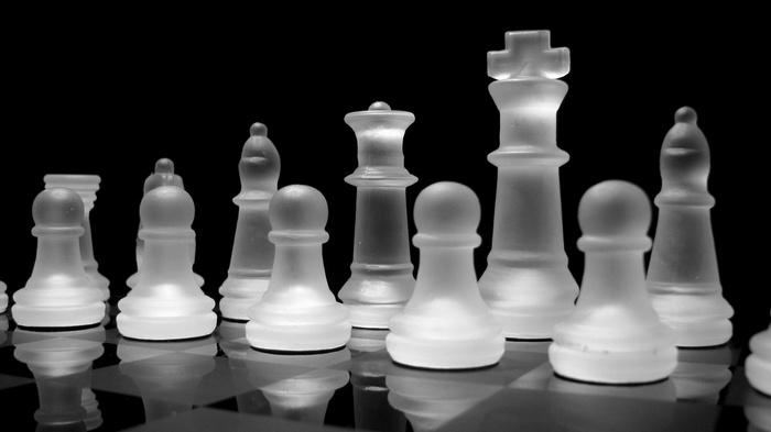 Glass chess pieces on a black background