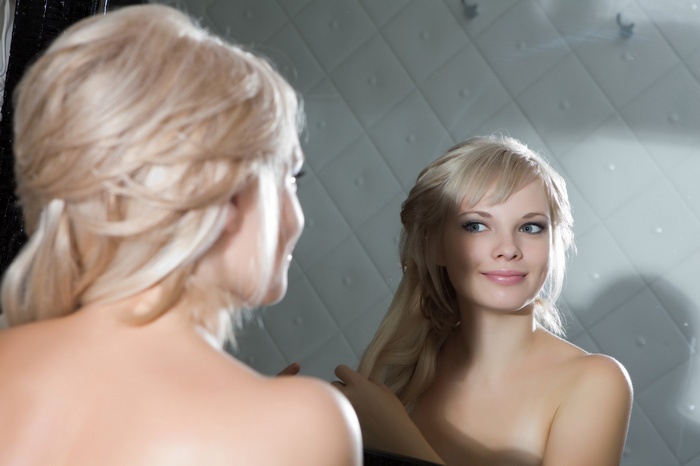 Feeona A, blonde model looking in mirror