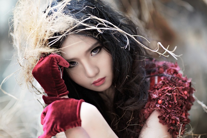 Asian woman with dark hair and red gloves