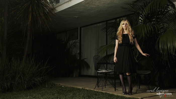 Avril Lavigne in a black dress outdoors