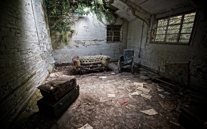 Abandoned room with couch and wheelchair