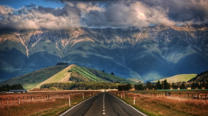 Road leading to mountains in New Zealand with clouds