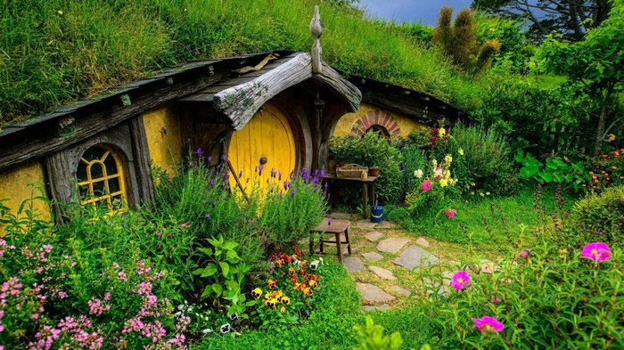 Hobbiton house with yellow door and garden in New Zealand