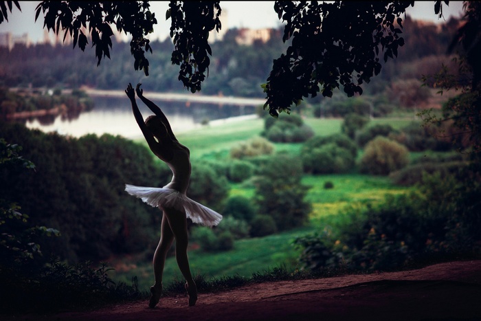 Ballerina dancing in a park by a lake