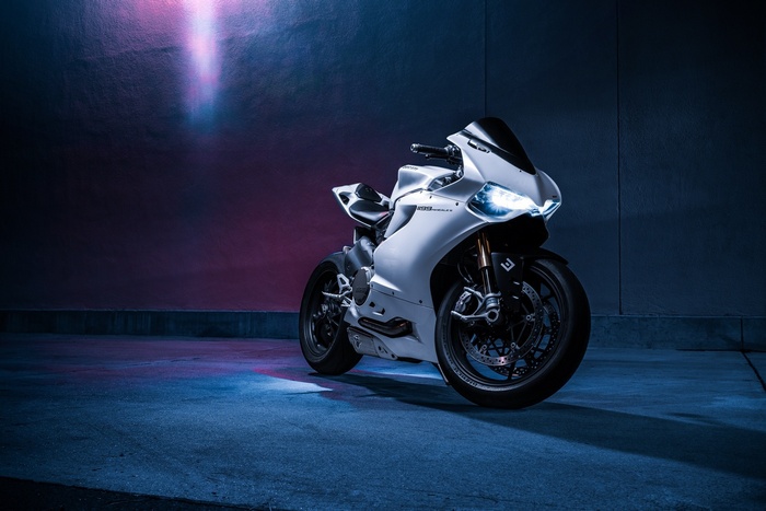 White Ducati 1199 motorcycle with headlights on