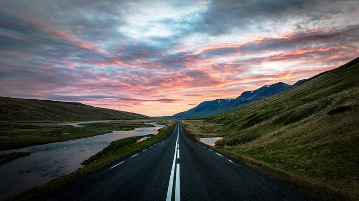Road through Iceland landscape at sunset