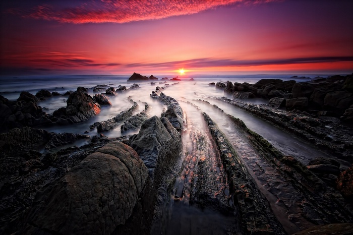 Sunset over rocky coastline with mist