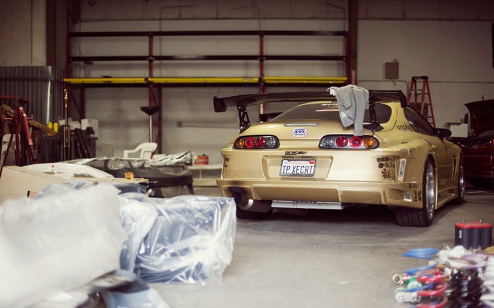 Gold Toyota Supra MK4 in a garage