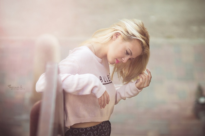 Woman with blonde hair wearing a pink sweater