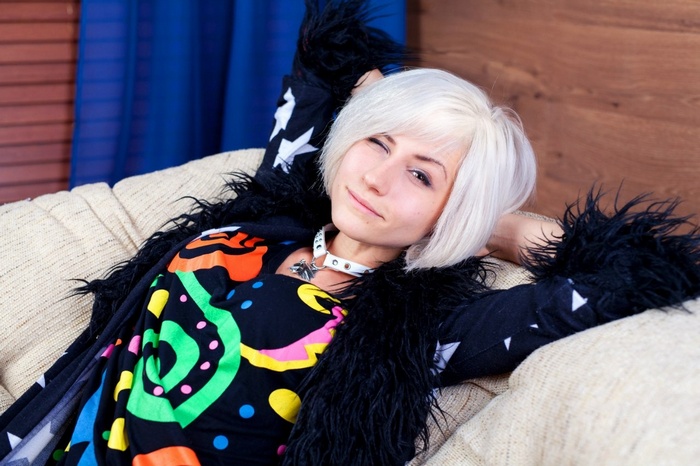 Julia Vlasova winks while lying on a couch