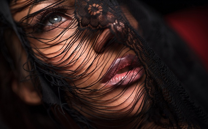 Woman with blue eyes behind a black veil