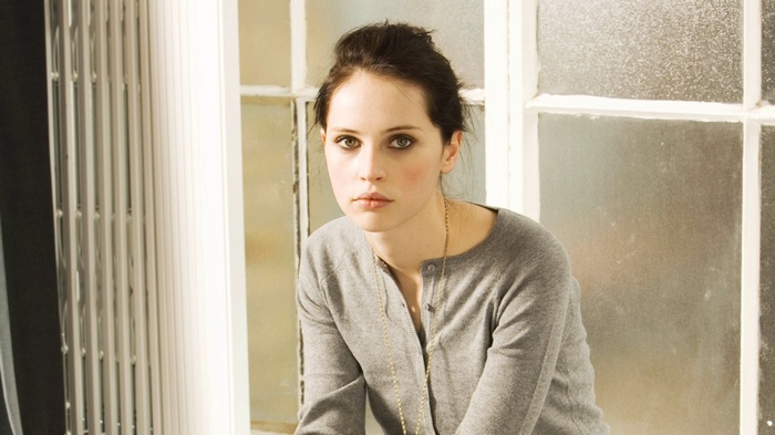Felicity Jones sitting by a window