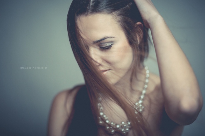 Woman with pearls and hair covering face