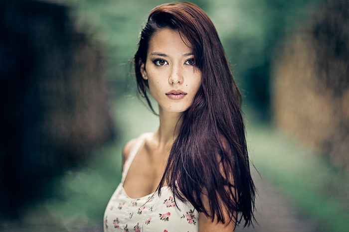 Portrait of a woman with long brown hair and freckles