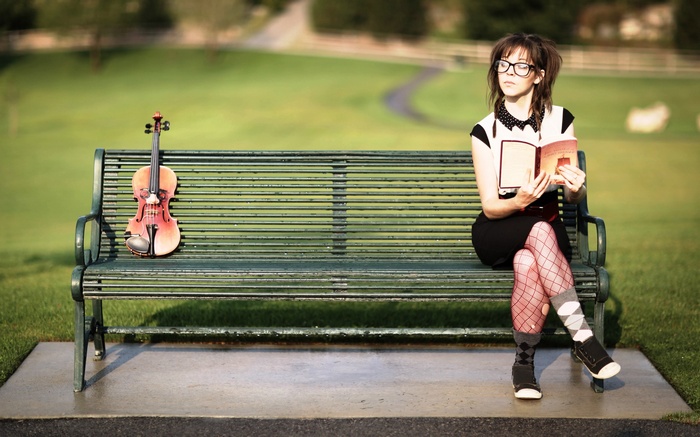 Lindsey Stirling with violin and book on bench